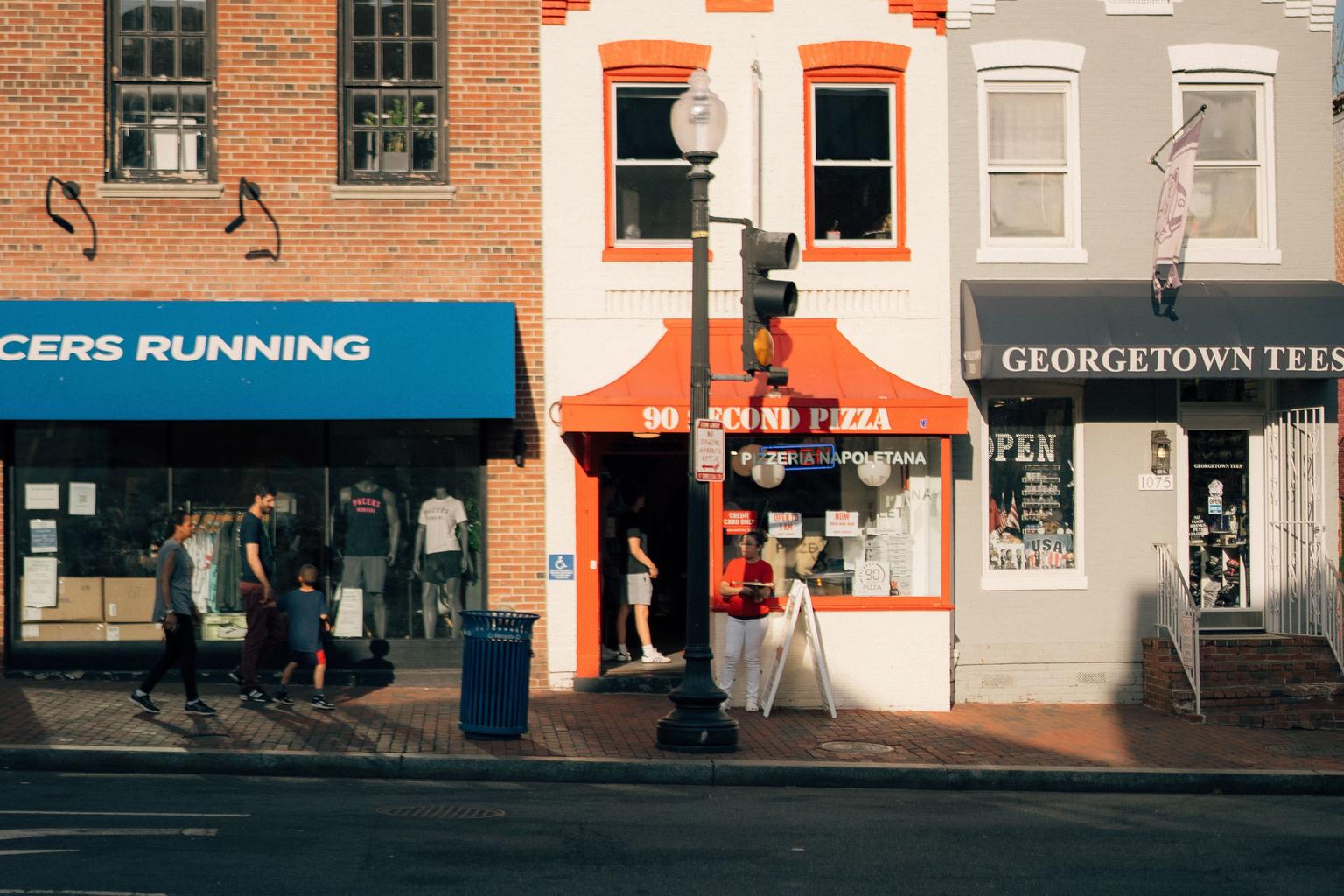 Independent storefronts and pedestrians line a street in Georgetown, Washington, D.C.
