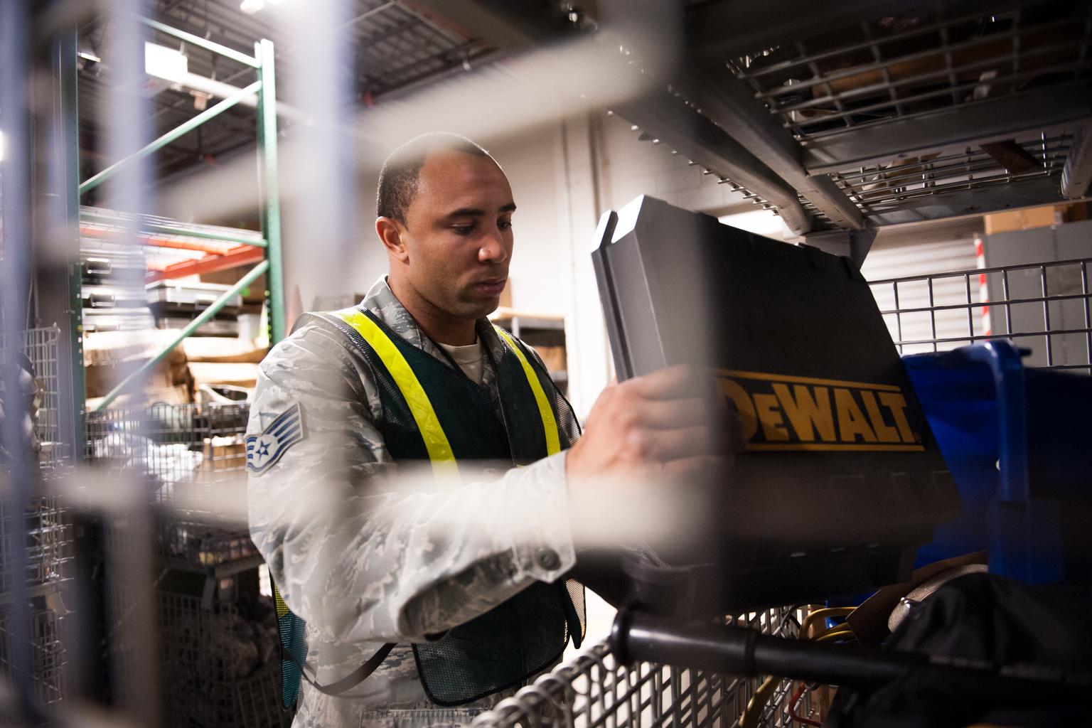 U.S. Air Force safety inspector examining an equipment case inside a New Jersey warehouse.