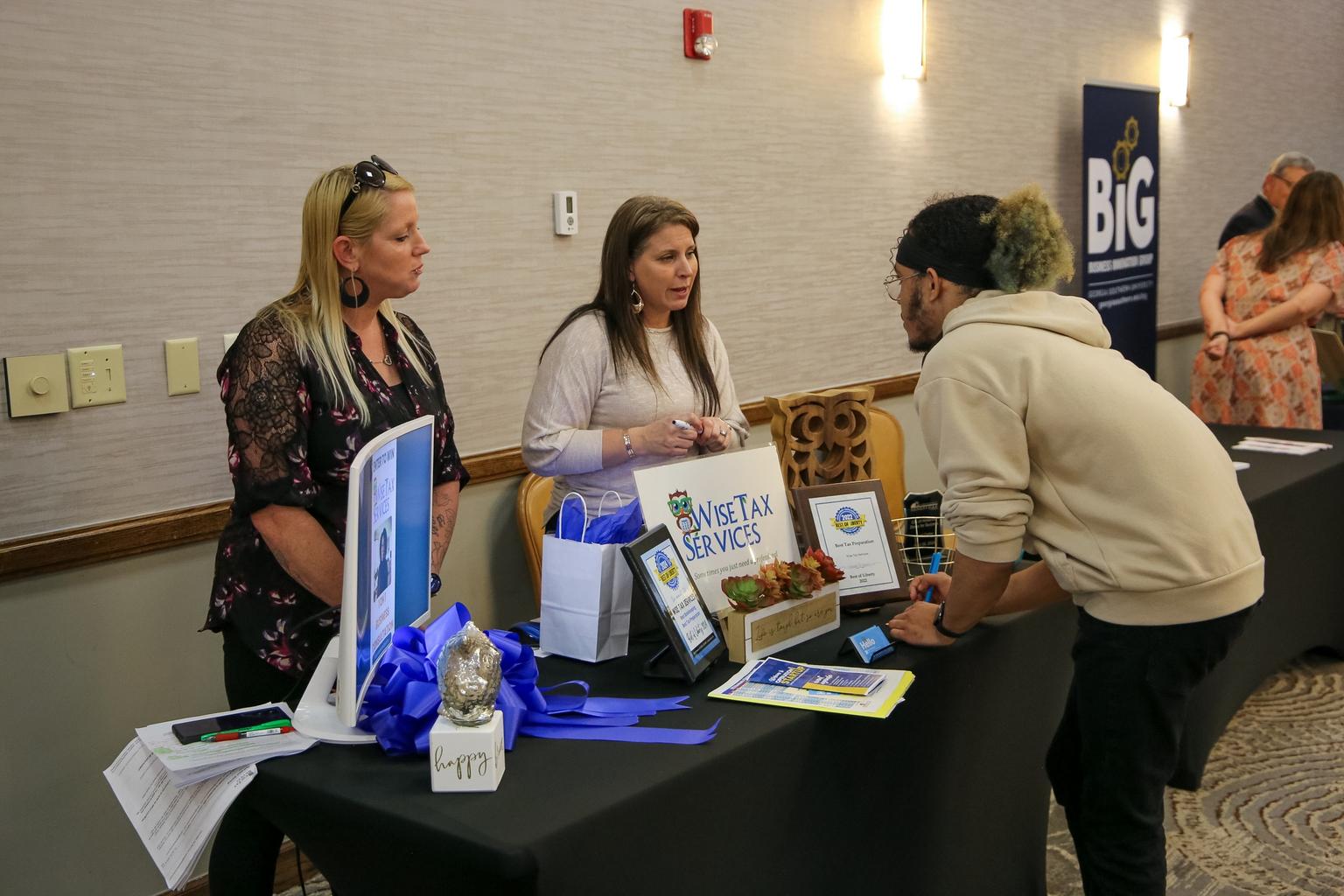 Representatives of Wise Tax Services speak with an Operation StartUp attendee at Fort Stewart, Georgia.