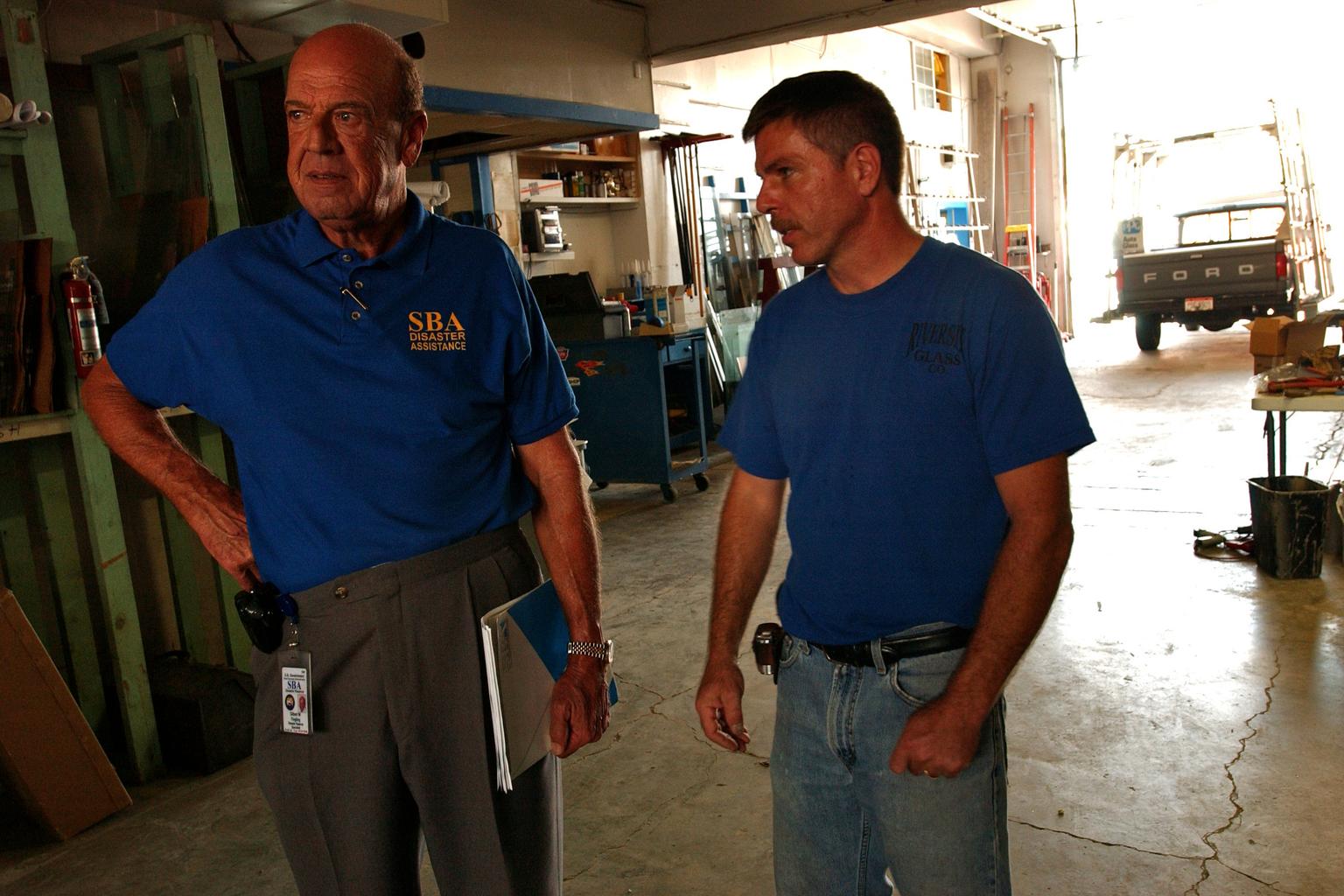 An SBA Disaster Assistance representative speaks with a local glass-shop owner inside his workshop in Findlay, Ohio.