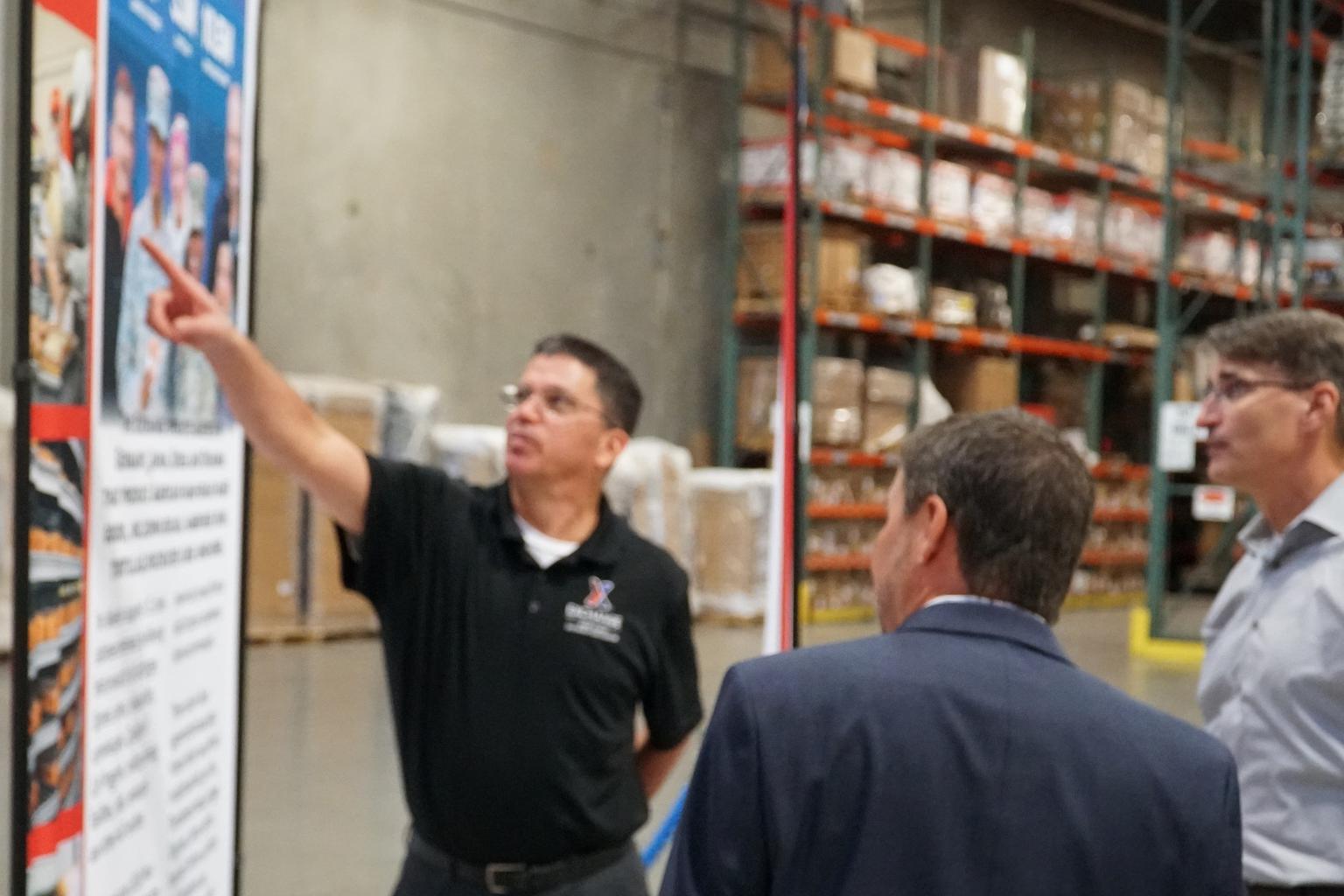 West Coast Distribution Center manager Kent Altom briefs visitors inside the Exchange warehouse at Sharpe Army Depot, California.